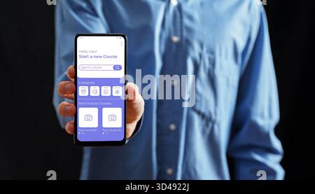 Hand holding a mobile phone showing an educational app with courses, categories, and a search bar for online learning Stock Photo