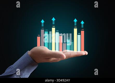 Hand holding a holographic bar chart with upward arrows, symbolizing data analysis, financial growth, and successful investment Stock Photo