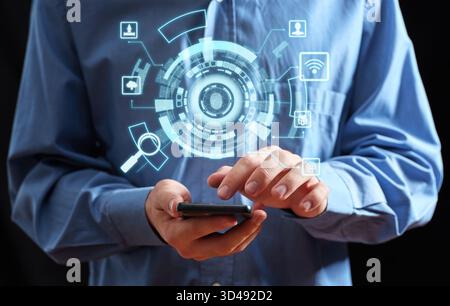 Person using a smartphone with a holographic interface showing security features, cloud computing, and a fingerprint scanner Stock Photo