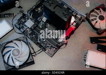 A set of parts for assembling and repairing a computer. Angle from above, everything is on the table, laid out, neon light. Stock Photo