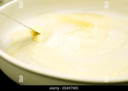 Butter in a pan, put butter in a pan before starting to fry Stock Photo