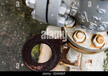Rusty pipe with a bolt on it. The bolt is missing. The pipe is old and rusted Stock Photo
