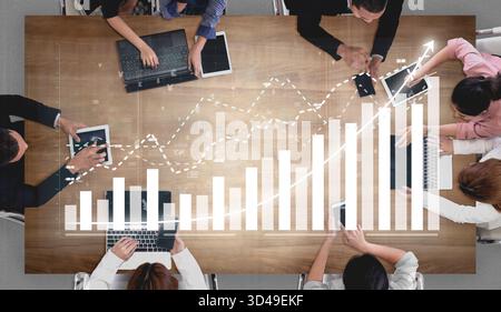 A dynamic business meeting scene showcasing professionals analyzing charts and data on digital devices. The image captures teamwork and strategic Stock Photo