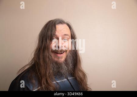 A man with a beard and long hair is smiling Stock Photo