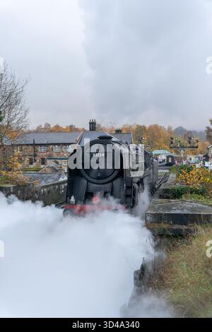 Steam locomotive 92134 departing Grosmont station with dramatic white steam clouds Stock Photo