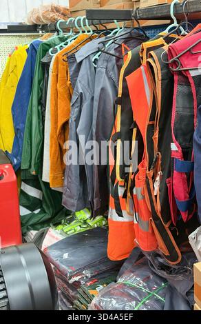 Assorted Workwear and Safety Vests Displayed on Store Rack Stock Photo