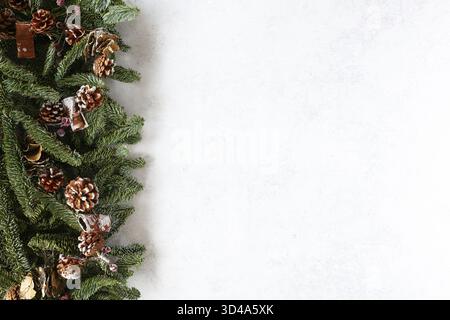 Christmas background with fir branches and snowy pine cones. White holiday background card with space for text Stock Photo