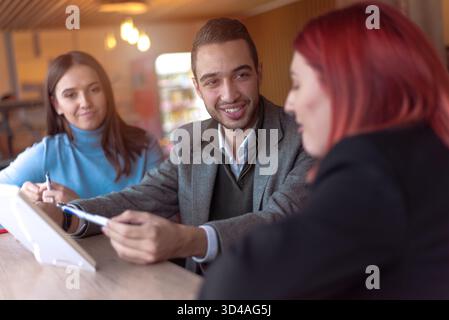 A group of young professionals having a friendly business meeting in a modern cafe. Stock Photo
