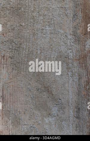 Weathered wood plank showing rough grain and traces of aged concrete, creating a distressed abstract surface perfect for rustic backgrounds Stock Photo