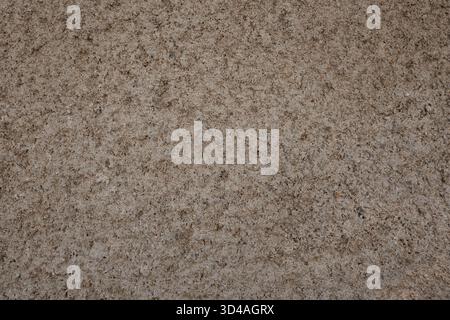 Rough concrete wall creating a textured background, showing a weathered surface with natural stone elements Stock Photo
