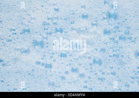 white soapy water on a blue background. Stock Photo