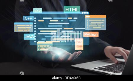 A modern programmer interacts with a laptop while virtual programming languages float above, illustrating an innovative approach to technology and Stock Photo