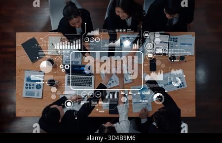 A high-angle view of a collaborative business meeting with professionals engaging in data analysis while interacting with digital charts and graphs Stock Photo