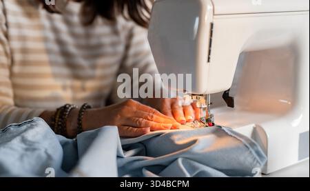 Woman's Hands Sewing On A Machine In Close-Up Stock Photo