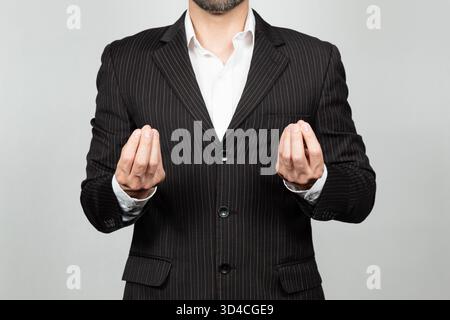 Close up to a business man on suit doing a typically italian expression with his hands and a white background Stock Photo