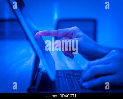 Close-up hand working on tablet with keyboard, representing modern technology, freelance software engineering, coding remotely, mobile development, an Stock Photo