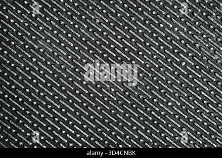 Metal texture with a geometric embossed pattern. Close-up of a shiny metallic surface with repeating elements. Stock Photo