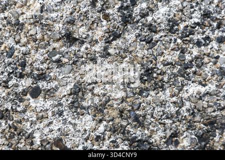 Detailed close up of rough granite rock texture background showing natural mineral surface. solid grey stone pattern has strong and earthy feeling Stock Photo