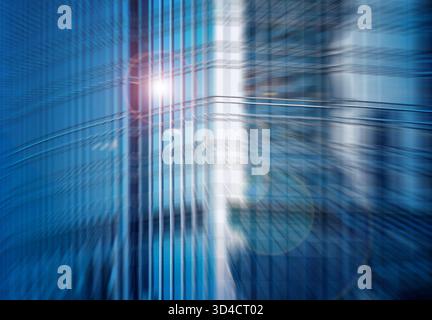 Dynamic architectural blur in an urban setting, featuring abstract city skyscrapers with a radial motion effect and light flare. Stock Photo