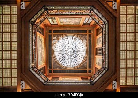 Looking up at the detailed octagonal skylight, wooden ceiling, and decorative glass of the entrance hall in the Hotel Pams, Perpignan, France Stock Photo