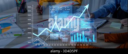 A professional business team collaborates in a modern office, analyzing growth data and using digital interfaces, charts, and graphs to enhance Stock Photo
