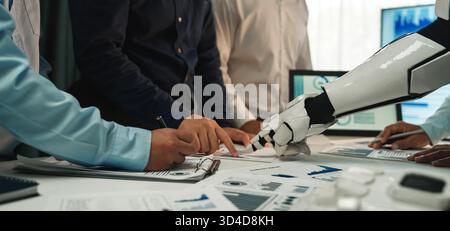 A modern office scene showcasing human professionals working alongside a robotic arm, focusing on data analysis and presentation of visual reports on Stock Photo