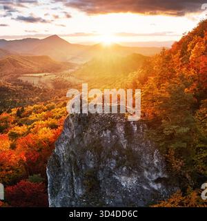 Man photographer in the mountains in autumn at sunset Stock Photo