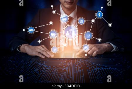 A businessman interacts with a digital tablet displaying technology icons that represent data analysis, innovation, and communication in a modern Stock Photo
