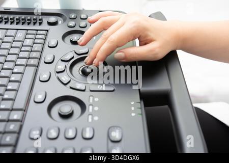 A person is using a modern medical device with an ergonomic design. The image focuses on the operational controls and suggests the device is used for Stock Photo