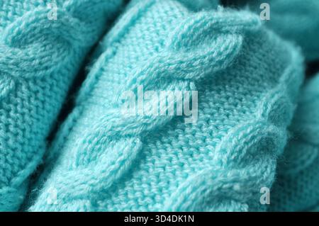Macro close-up: a delicate turquoise knitted fabric with visible stitches reminiscent of a woven pattern. Side view: angular perspective, blue, green, Stock Photo