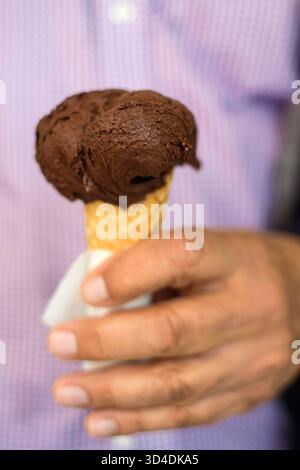 A chocolate gelato is held by a man in Montalcino, Italy. Stock Photo
