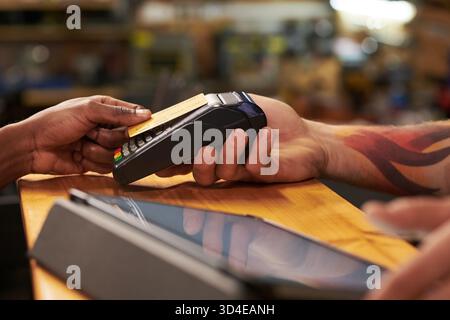 Man Holding Payment Terminal While Black Man Making Card Transaction Stock Photo