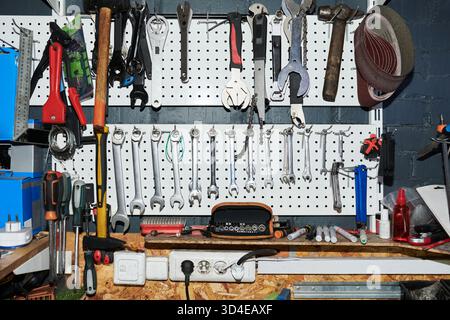 Assorted Hand Tools Hanging on Workshop Pegboard in Organized Arrangement Stock Photo