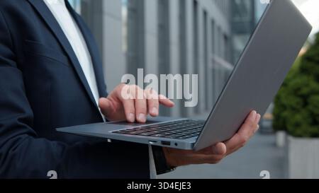 Close-up male hands unrecognizable business man typing laptop in city unknown businessman chatting with wireless computer pc keyboard male worker Stock Photo