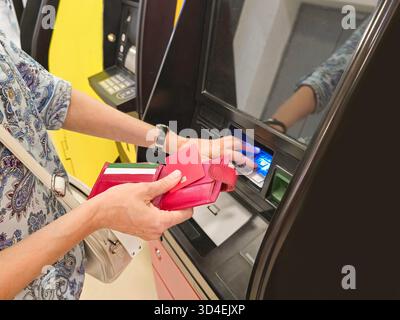 A woman's hand enters a digital PIN code on a atm machine. ATM close-up. Stock Photo