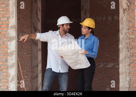 Architects and engineers work together to assess the residential home construction site's progress || Model released Stock Photo
