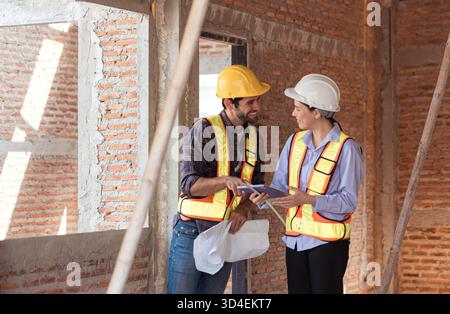 Architects and engineers work together to assess the residential home construction site's progress || Model released Stock Photo