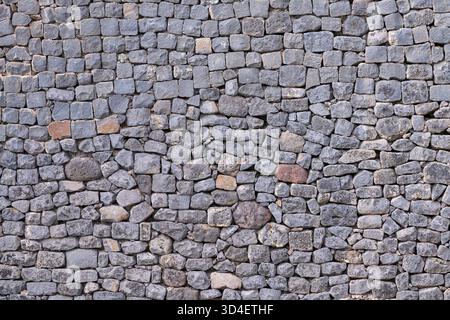 Gray wall made of many various stones Stock Photo
