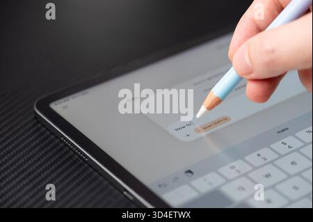 New York, USA - November 7, 2025: Asking Microsoft copilot AI chatbot on tablet close up view on dark table Stock Photo