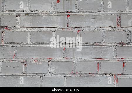 Weathered old grungy stone blocks wall texture background, grey with red patches and strokes seamless pattern Stock Photo
