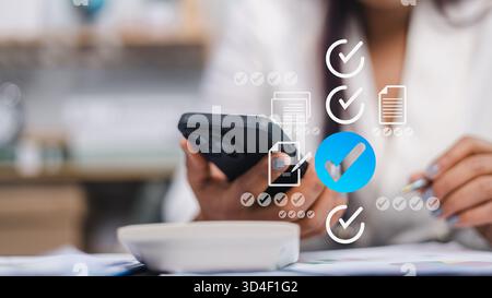 Close-up of businesswoman using smartphone with digital checklist icons, representing task management, productivity, and business organization in mode Stock Photo