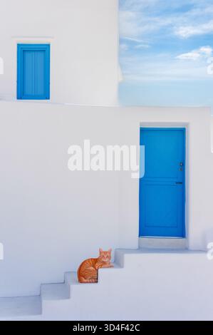 Ginger cat relaxing on white steps outside a traditional Greek island house Stock Photo