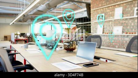 Featuring silver laptop centered on table in coworking space, sitting open with papers and AR pins Stock Photo
