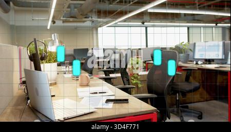 Featuring foreground workstation showing open laptop, smartphone, mug in open-plan office Stock Photo