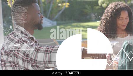 Sitting three adults chatting at backyard table, holding wine glasses, plaid shirt, white overlay Stock Photo