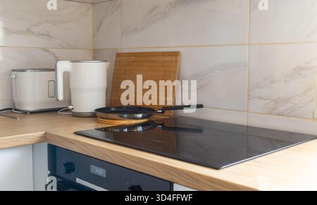 Modern kitchen corner with kettle and pan. Daily rituals, balance between function, order and warmth. Stock Photo