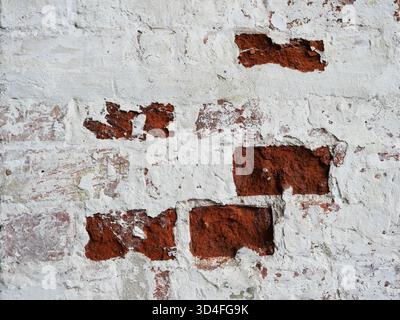 Weathered brick wall with peeling plaster historic facade and texture. Copyspace. Stock Photo