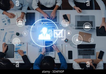 A group of professionals collaborates on KYC processes, utilizing high-tech devices and discussing information in a modern office setting filled with Stock Photo