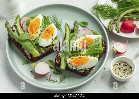 Food, Sandwich with dark rye bread, asparagus and egg on white background Stock Photo