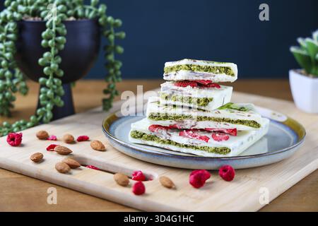 Food, Piece of trend Dubai white chocolate with pistachio paste and kataifi dough, Confectionery handmade sweets at home in the kitchen. Stock Photo